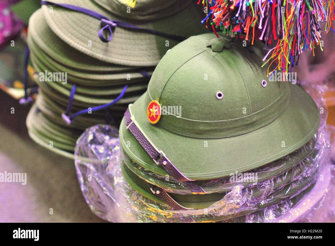Nha Trang, Vietnam - Febbraio 6, 2016: casco di soldati vietnamiti sono in vendita per i viaggiatori in un mercato locale in Vietnam Foto Stock