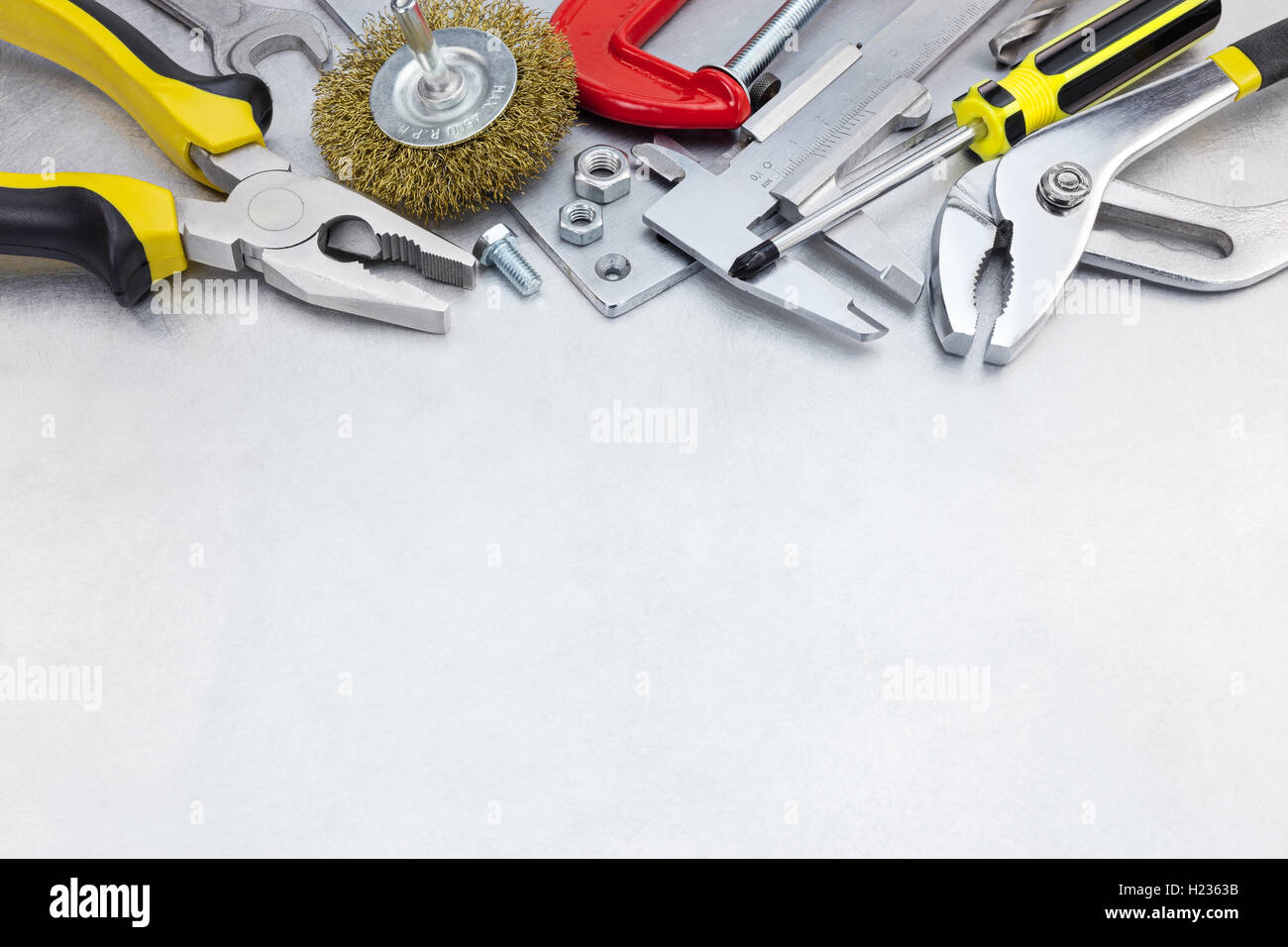 Set di strumenti vari per la riparazione della casa e il lavoro a mano sulla superficie metallica sullo sfondo Foto Stock