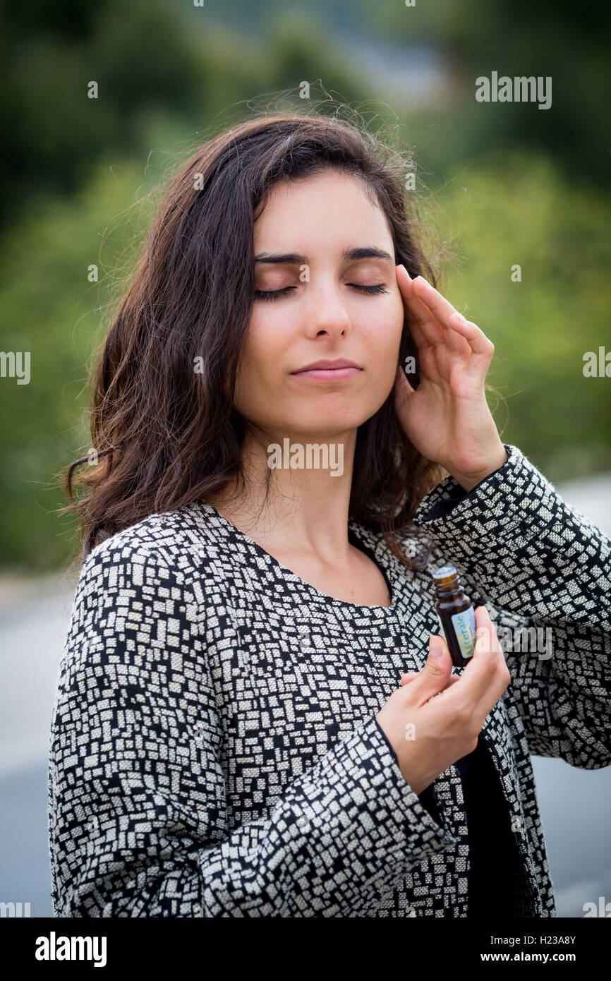Donna l'applicazione di olio essenziale per il suo tempio. Foto Stock
