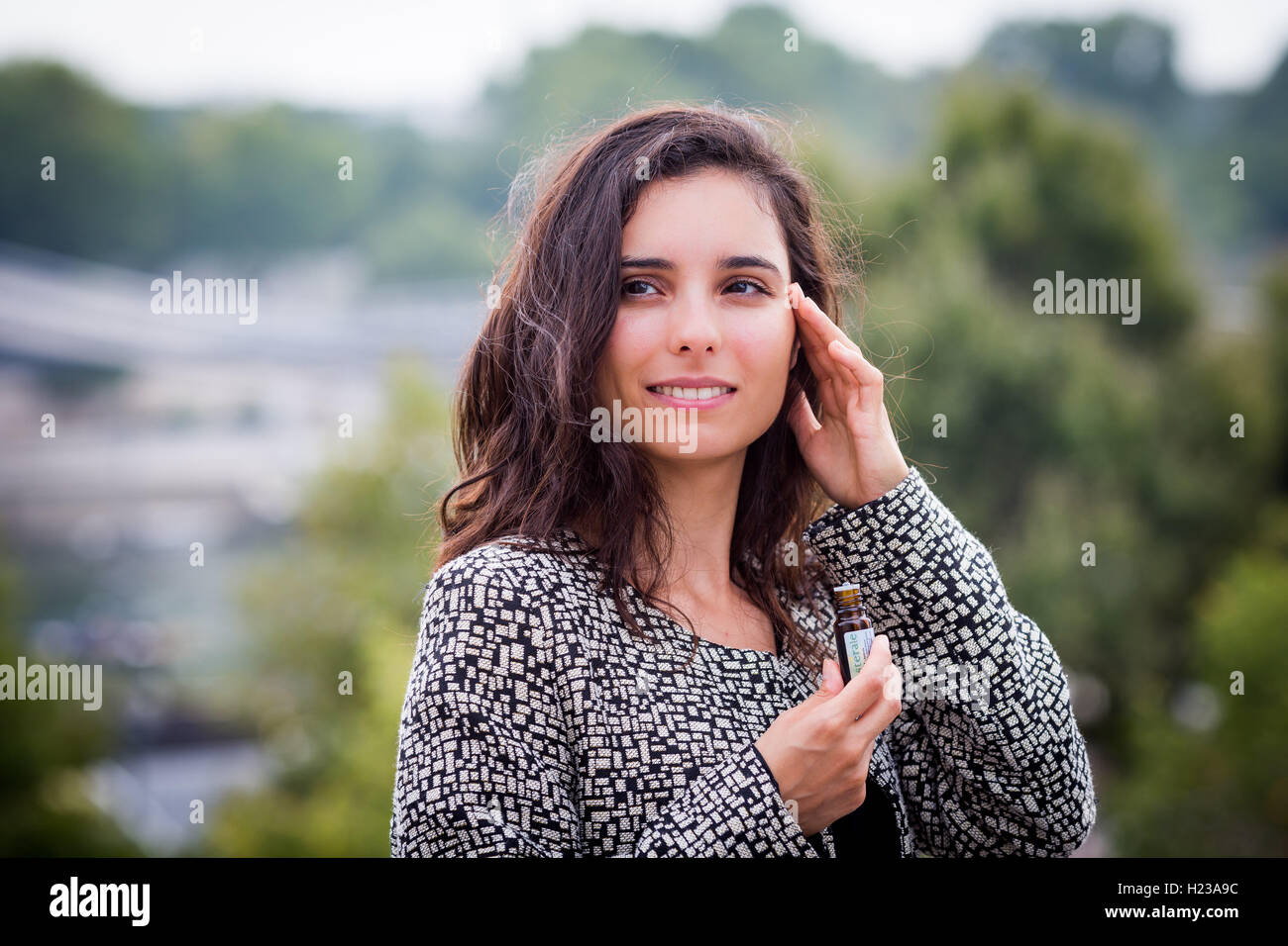 Donna l'applicazione di olio essenziale per il suo tempio. Foto Stock