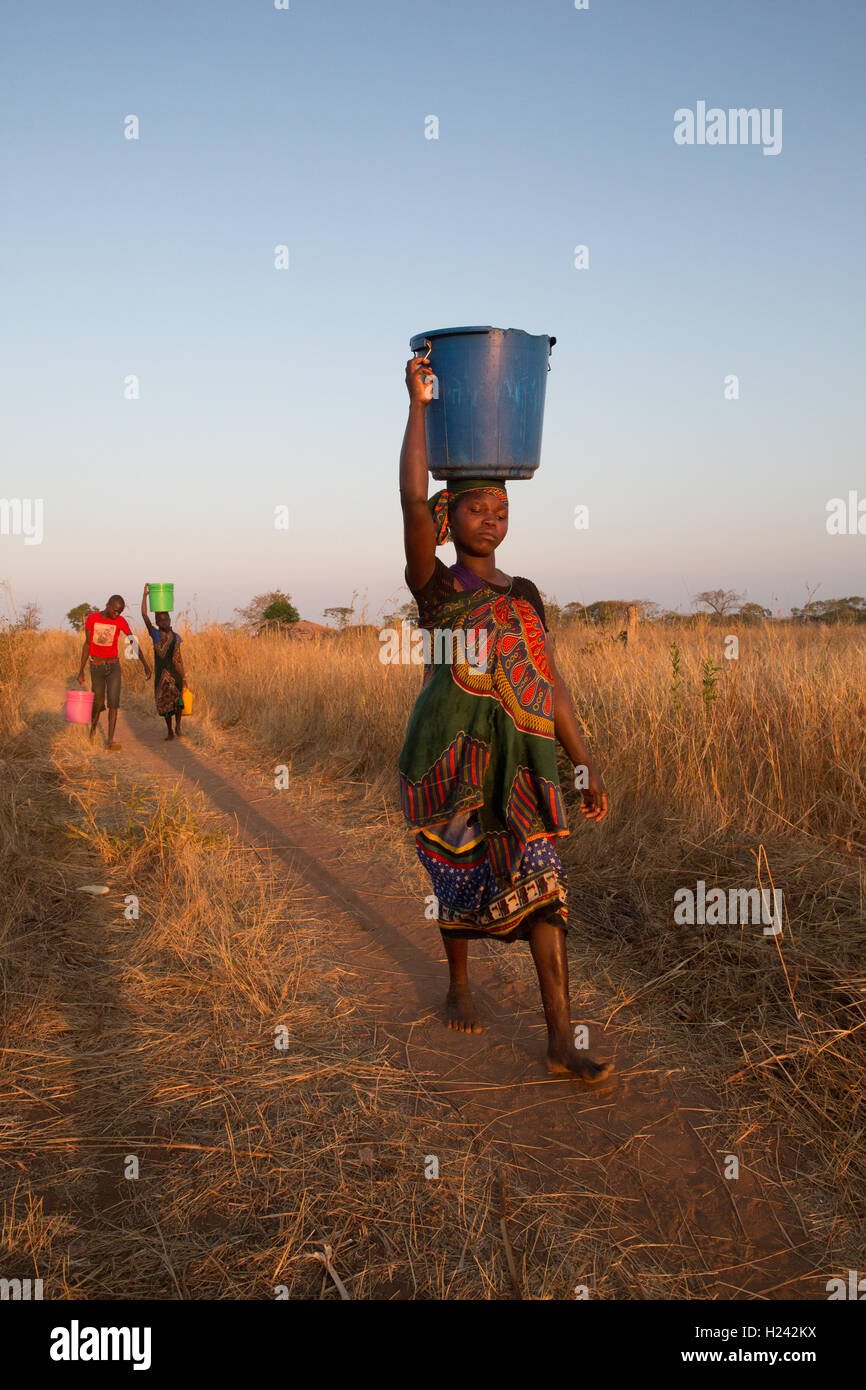 Distretto Lalaua, Nampula Provincia, Mozambico, Agosto 2015: Laurinda Diego i bambini prendere l'acqua da un pozzo vicino. Foto di Mike Goldwater Foto Stock