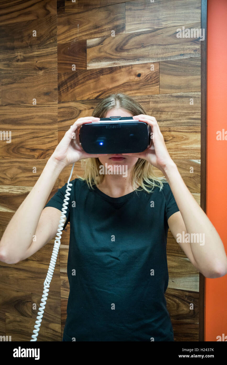Donna che indossa una realtà virtuale auricolare. Foto Stock