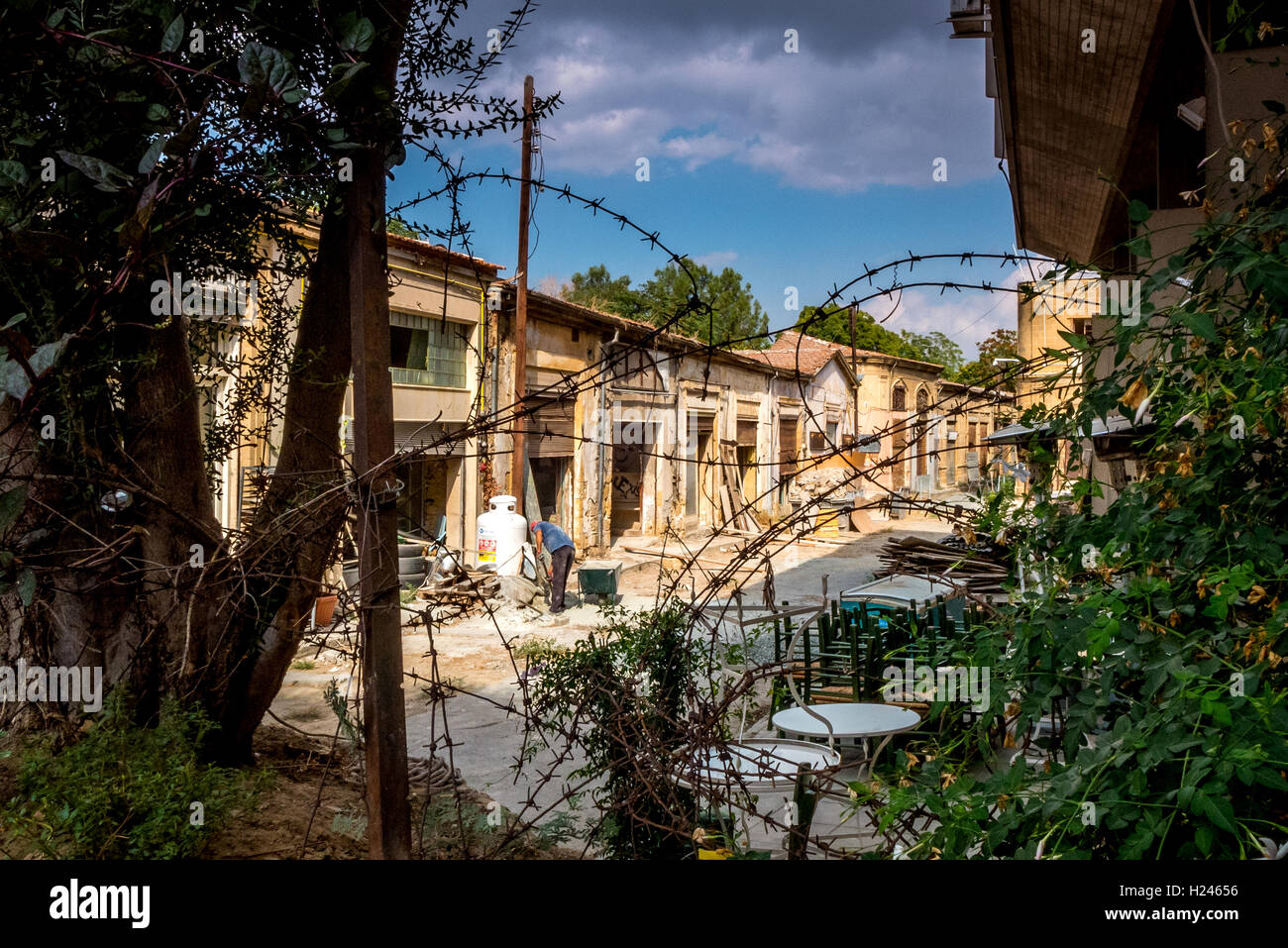 Un uomo che lavora nella zona cuscinetto tra i due lati della città divisa di Nicosia Foto Stock