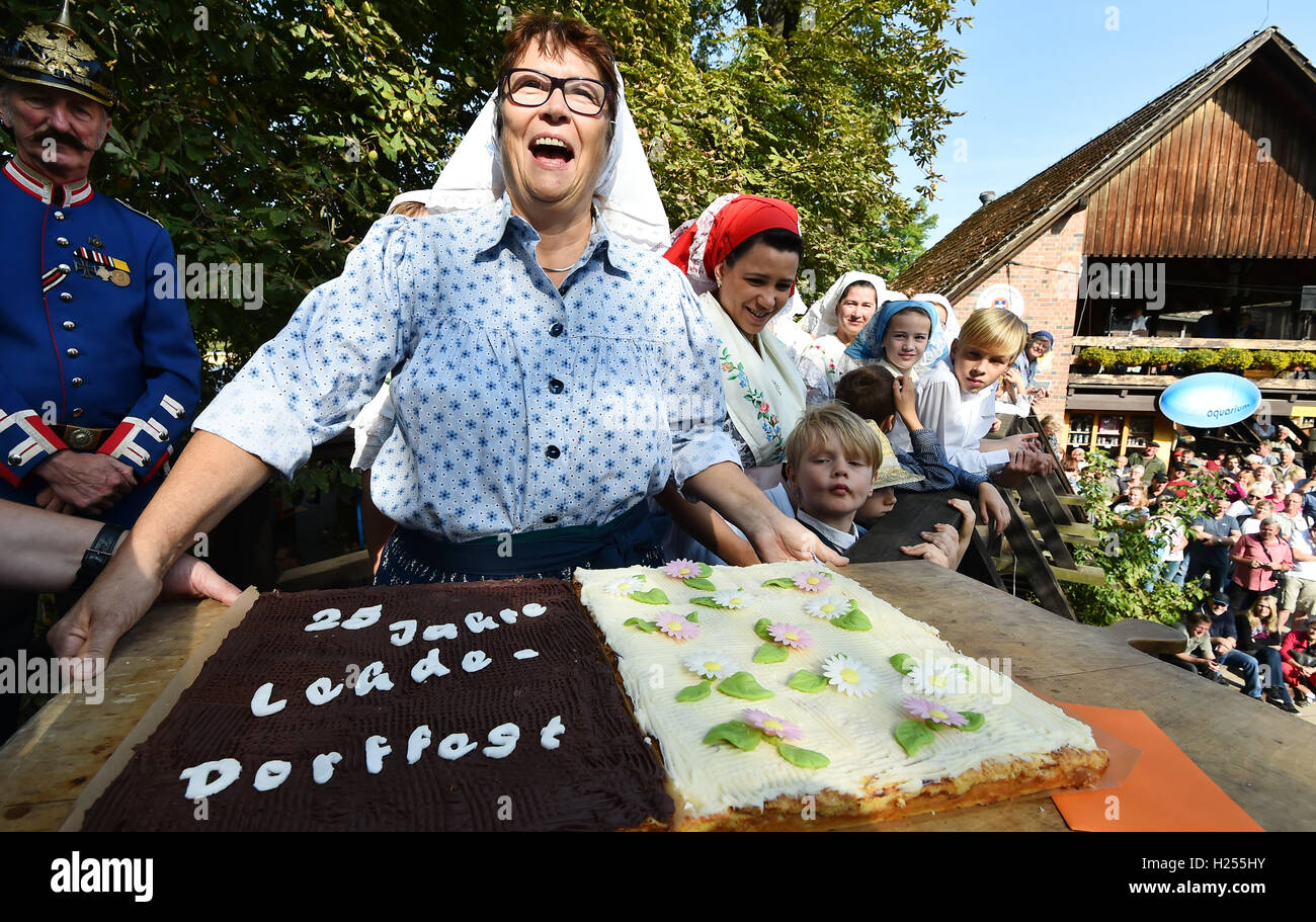 Lehde, Germania. 24Sep, 2016. Una donna in costume tradizionale porta una torta di compleanno con scritto "25 anni Lehde Village Festival' in corrispondenza della apertura della Spreewald festival in Lehde, Germania, 24 settembre 2016. Foto: BERND SETTNIK/dpa/Alamy Live News Foto Stock