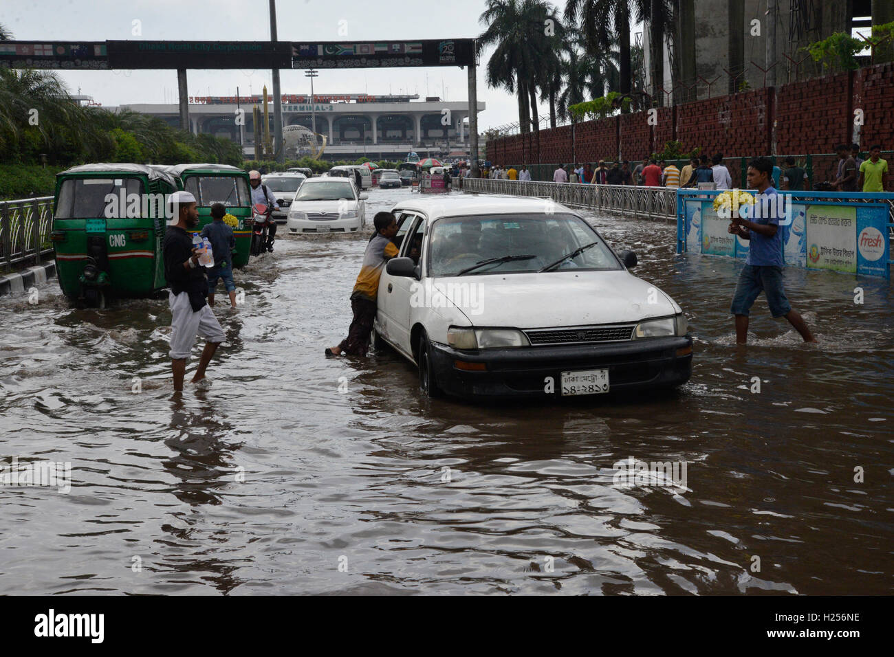 Dacca in Bangladesh. 24Sep, 2016. Veicoli tentano di guida attraverso la saturo di acqua uscita di strada di Shahjalal International Airport a Dhaka, nel Bangladesh. Il 24 settembre 2016 pesante acquazzone di monsone causato estreme waterlog nella maggior parte delle aree della città di Dhaka, Bangladesh. Le strade sono state sommerse rendere il viaggio lento e dannosa. Credito: Mamunur Rashid/Alamy Live News Foto Stock