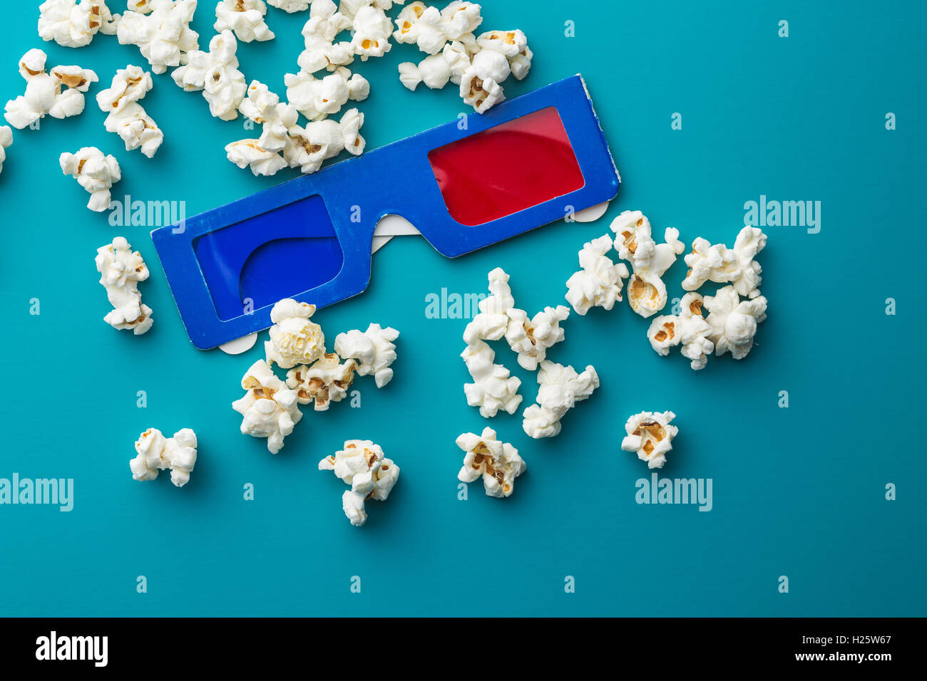Popcorn e occhiali 3D su sfondo blu. Foto Stock