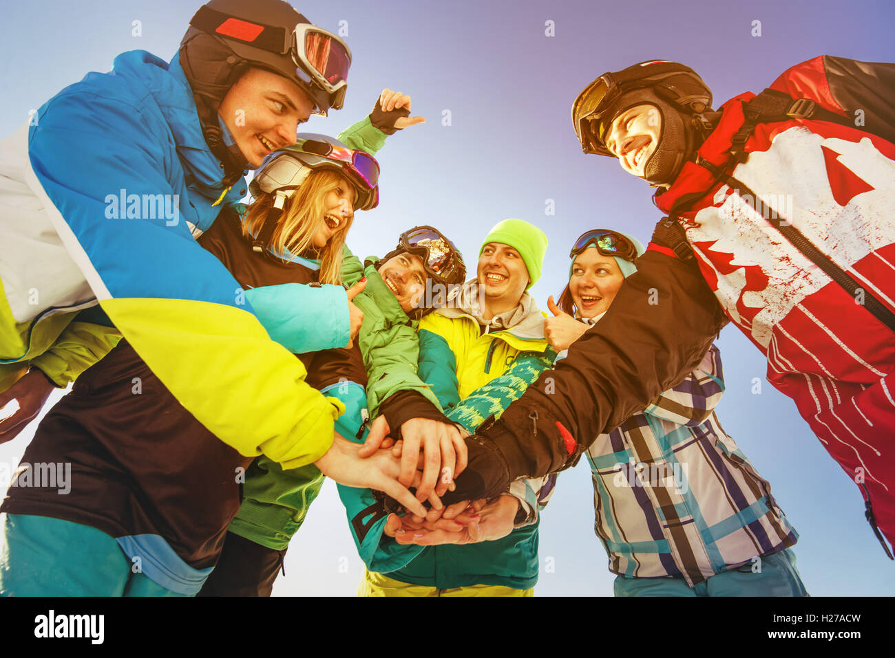 Team di snowboarder si erge sul cielo blu sullo sfondo di montagne Foto Stock
