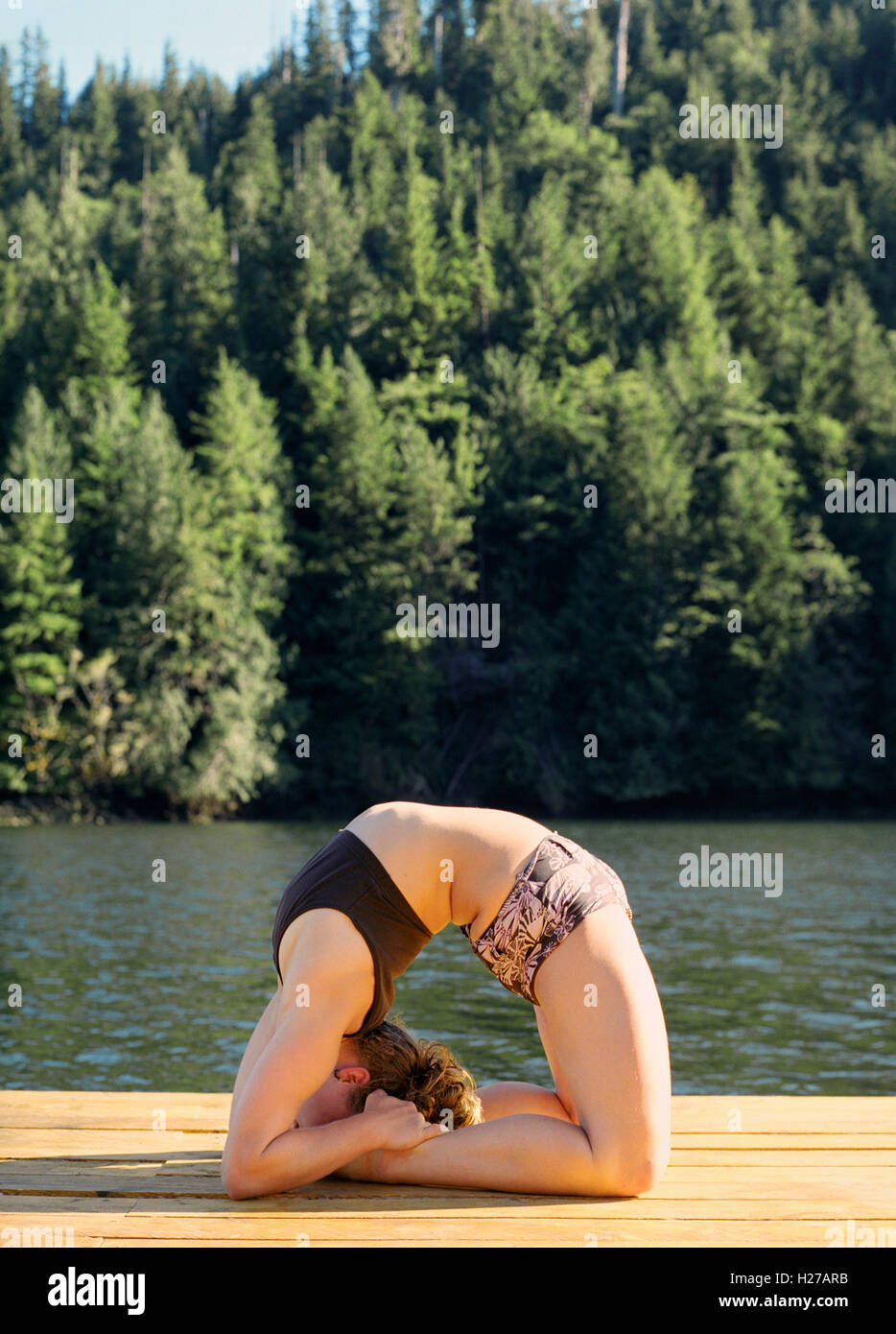 Nimmo Bay resort istruttore yoga le pratiche yoga sul dock al tramonto. La British Columbia, Canada. Foto Stock