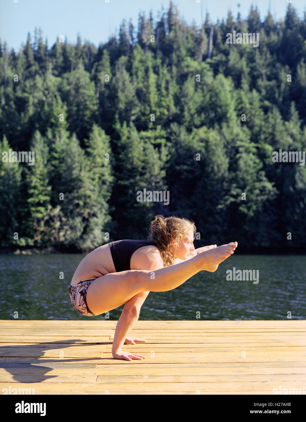 Nimmo Bay resort istruttore yoga le pratiche yoga sul dock al tramonto. La British Columbia, Canada. Foto Stock