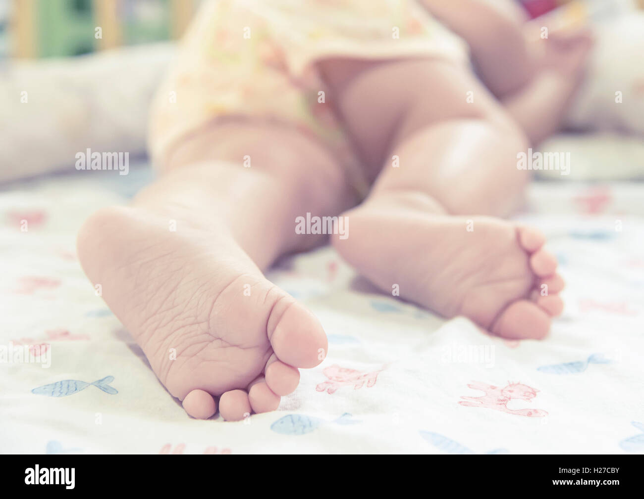 Close up piedi del bambino mentre dorme sul letto Foto Stock