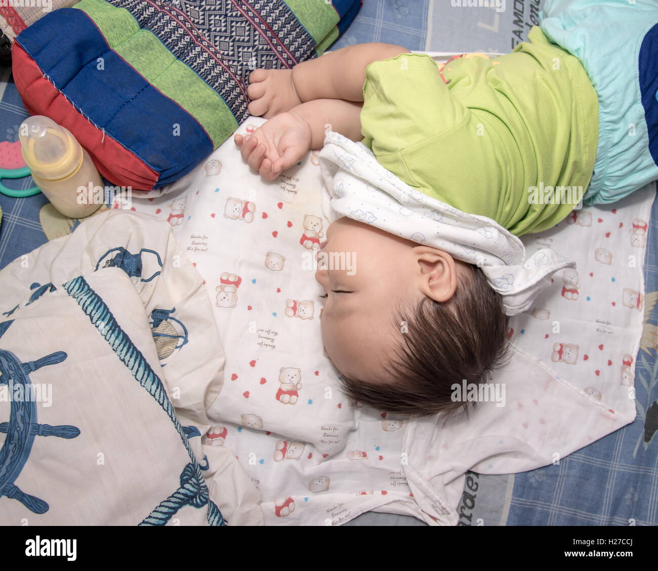 Asian bimbo che dorme sul letto , con la sua mano destra tenendo la  bottiglia di latte, Top View foto Foto stock - Alamy
