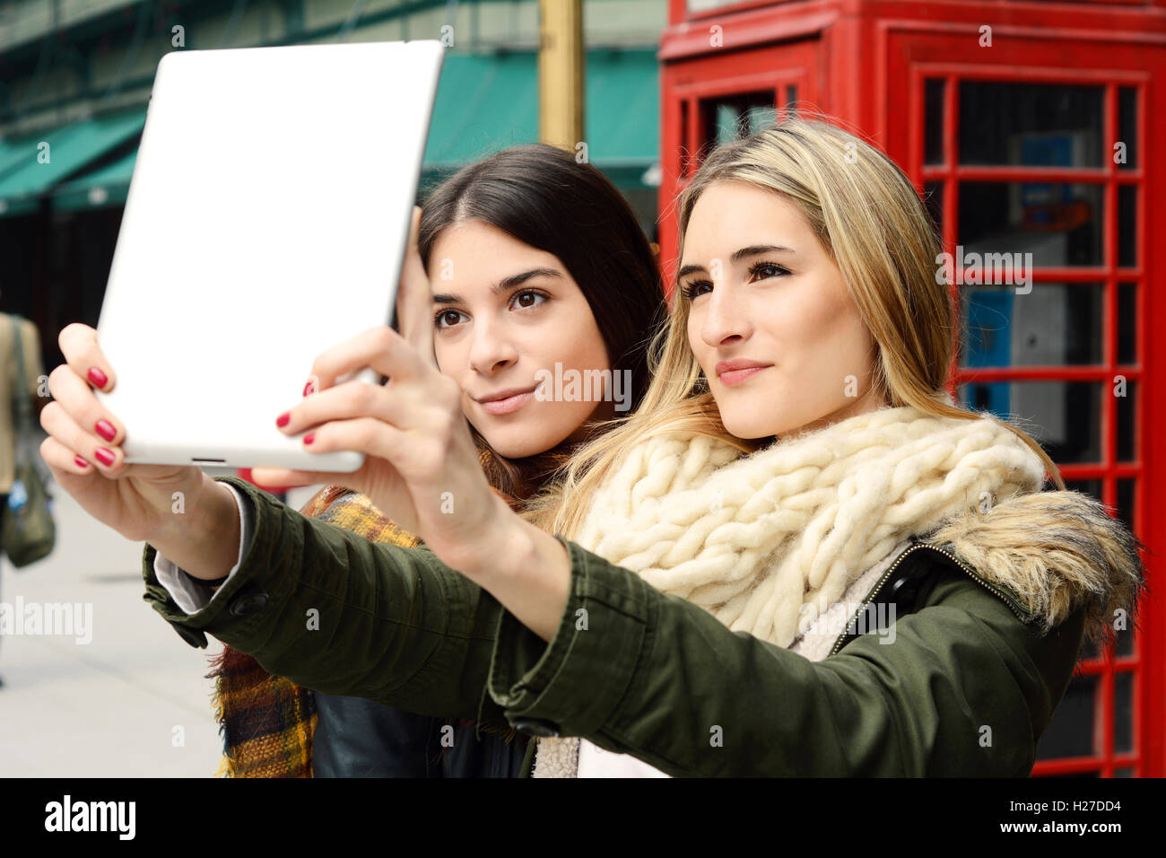 Ritratto di due giovani amiche tenendo selfie con la compressa in un viaggio insieme. Il concetto di turismo. All'esterno. Foto Stock