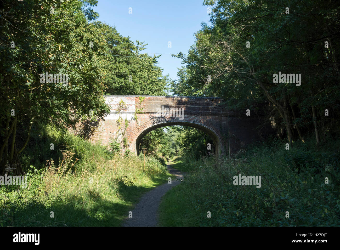 A piedi sotto il ponte di mattoni su vecchie Stour Valley Railway in country park Clare Suffolk Inghilterra 2016 Foto Stock