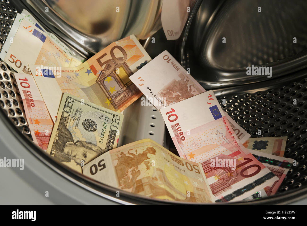 Il denaro nella macchina di lavaggio. La carta delle banconote in euro nel servizio lavanderia. Valuta nella macchina di lavaggio. Foto Stock