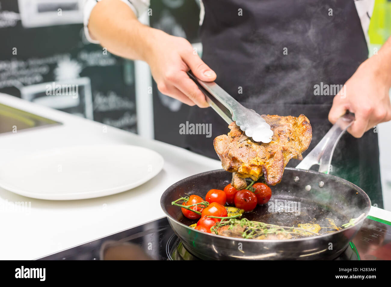 Lo Chef la cottura della carne Foto Stock