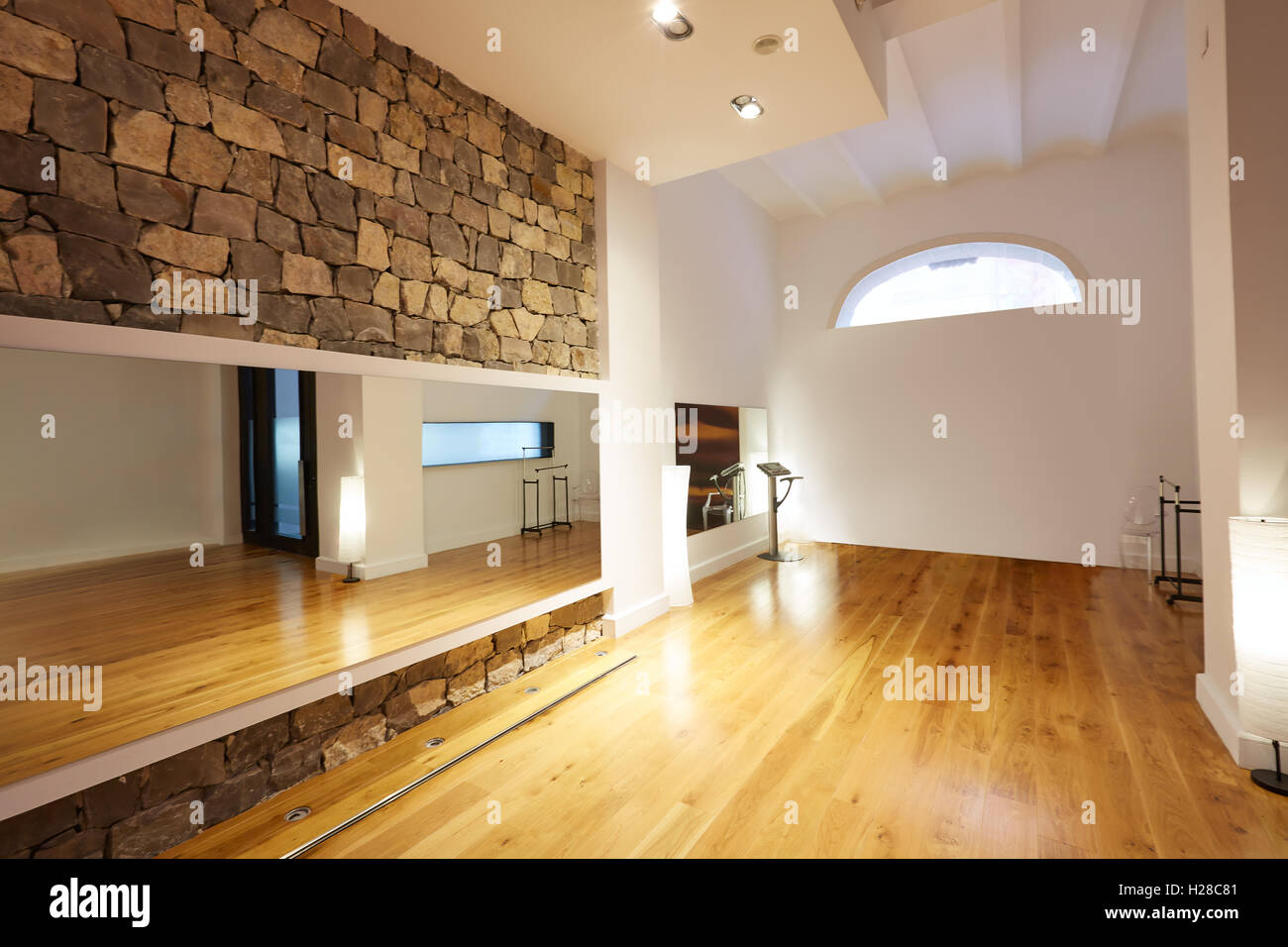 Palestra interna con pavimento in legno e specchio di muro di pietra Foto Stock