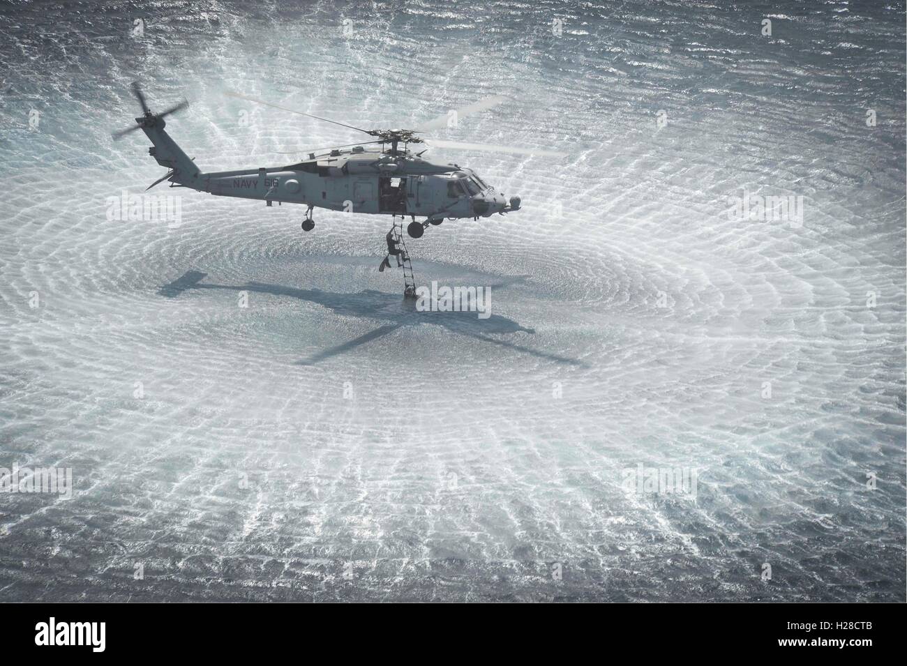 Un U.S. Navy SEAL operazioni speciali commando si inerpica su una scala per un HH-60H Seahawks elicottero durante un EOD heliocasting esercizio Aprile 12, 2015 in mare Arabico. Foto Stock