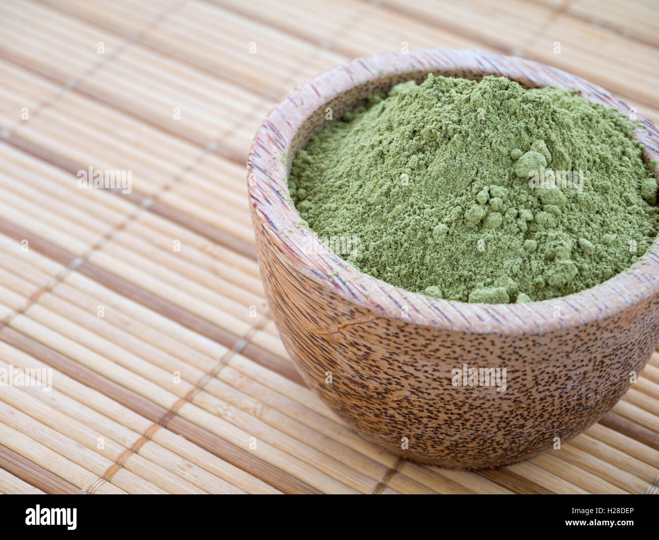 Henné in polvere nella tazza di cocco sul tappetino di bambù sfondo Foto Stock