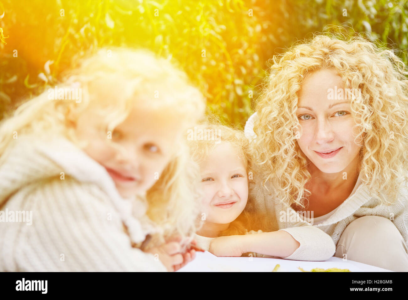 Famiglia con bambini il disegno e la pittura in giardino con servizio di babysitter Foto Stock