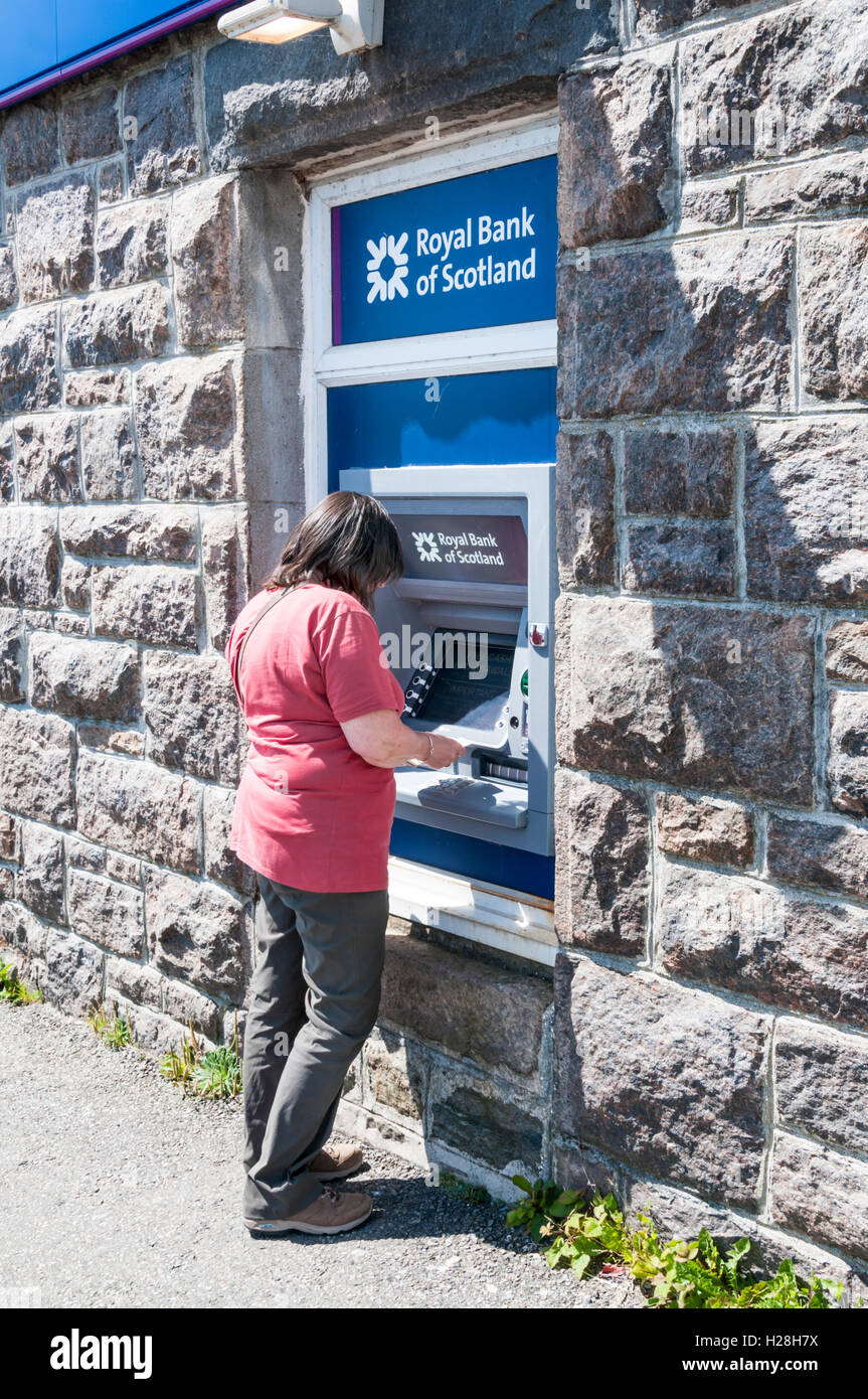 Donna che utilizza un RBS bancomat sull isola di Barra nelle Ebridi Esterne. Foto Stock
