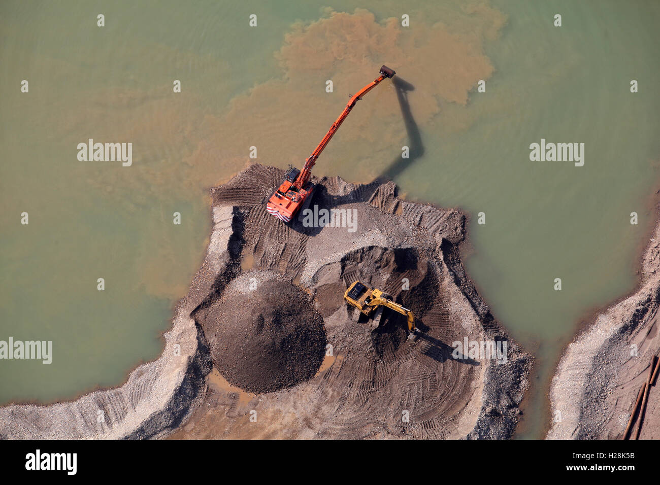 Vista aerea di due scavatori lavorare accanto a una laguna in una cava in Yorkshire, Regno Unito Foto Stock