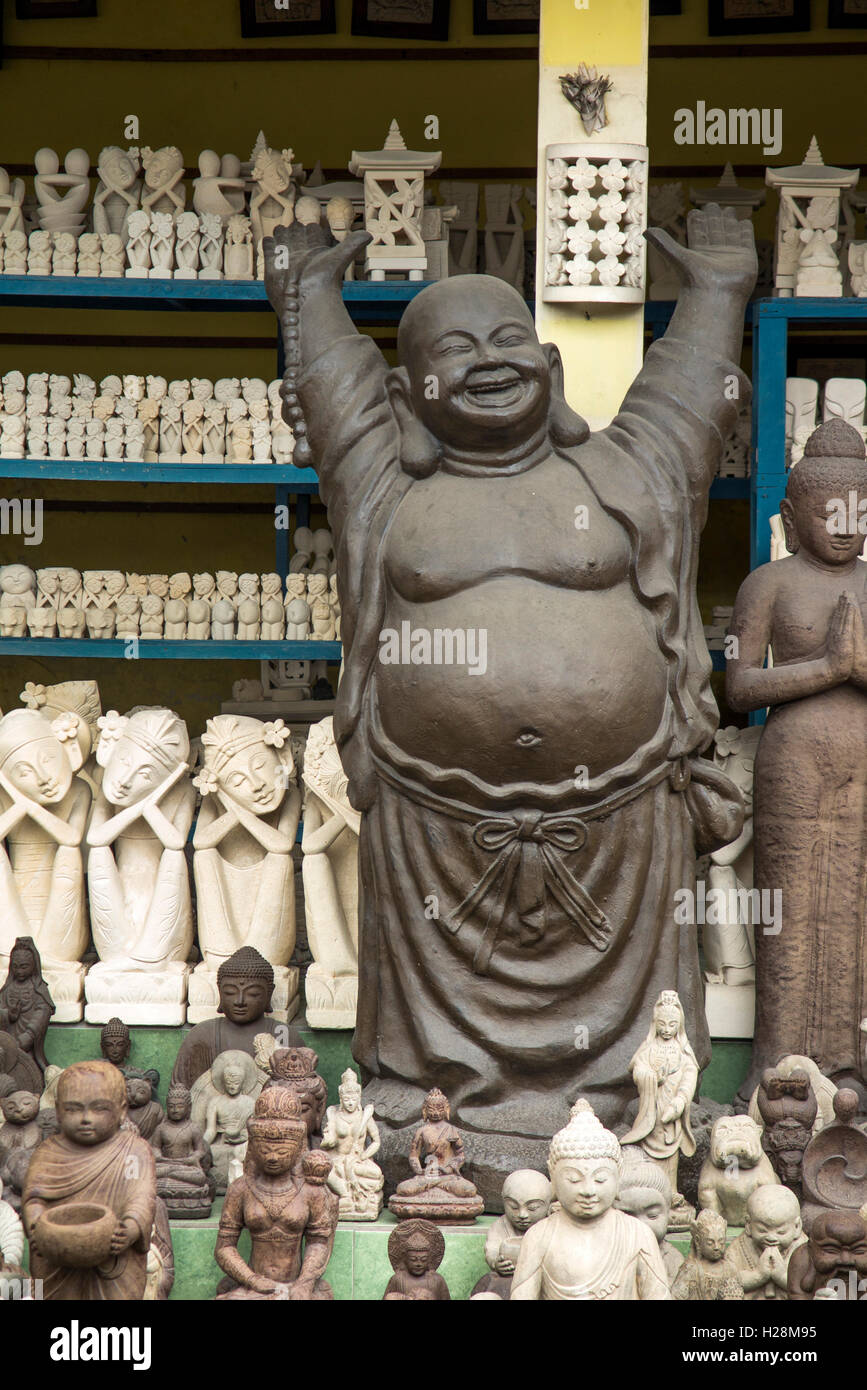 Indonesia Bali Ubud, Peliatan, Jl. Raya Andong, Felice Jolly con i bracci sollevati nel negozio di artigianato Foto Stock