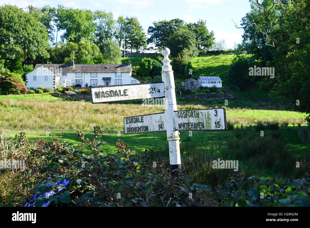 Direzione segno posto a Santon Bridge, Cumbria, Inghilterra, Regno Unito. Foto Stock