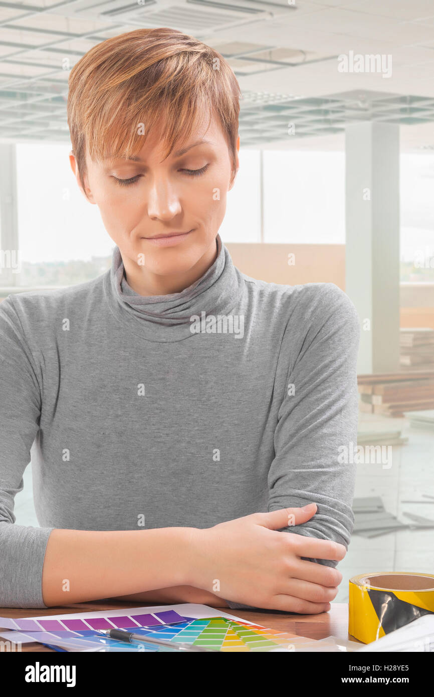 Lavoratore di sesso femminile che a tavola vedere sulla tavolozza dei colori Foto Stock