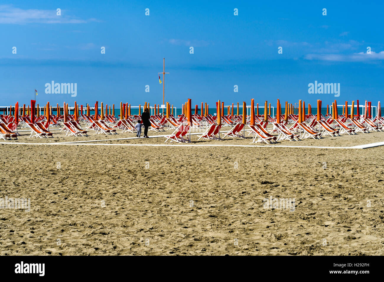 Arancione vuota di sedie a sdraio e ombrelloni sulla spiaggia, inizio di stagione, Viareggio, Toscana, Italia Foto Stock