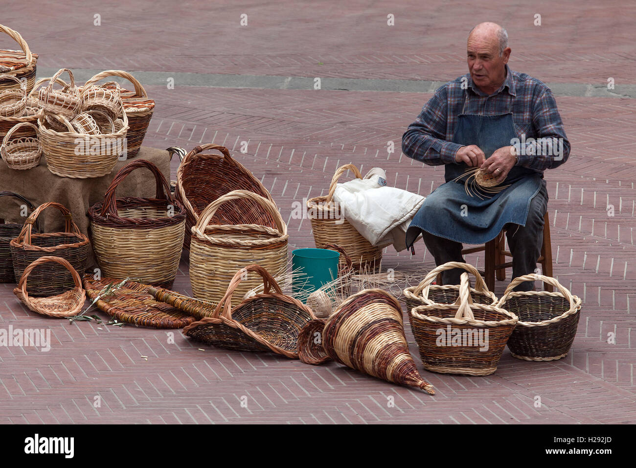 Cestello weaver, uomo sulla Piazza delle Erbe rendendo ceste, San Gimignano Provincia di Siena, Toscana, Italia Foto Stock
