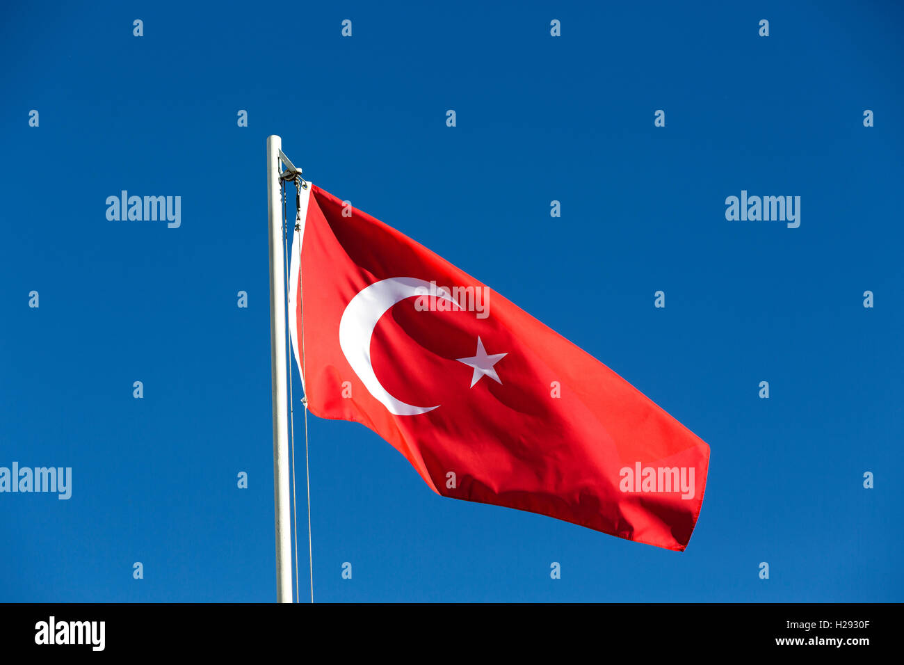 Bandiera nazionale della Turchia su un pennone di fronte blu cielo Foto Stock