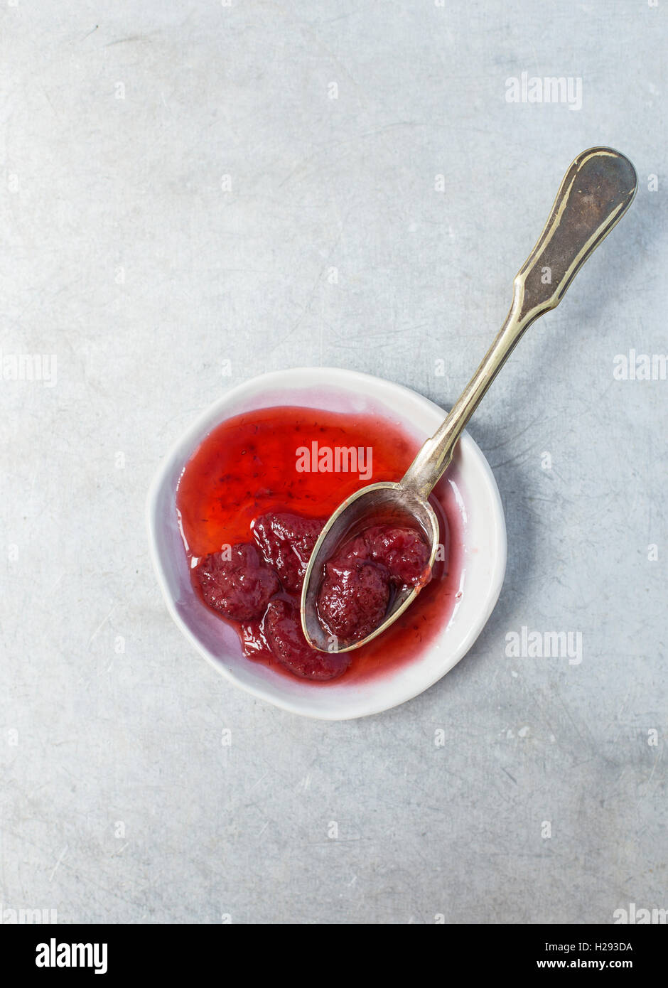 Deliziosa confettura di fragole in un piccolo piattino con un cucchiaio Foto Stock