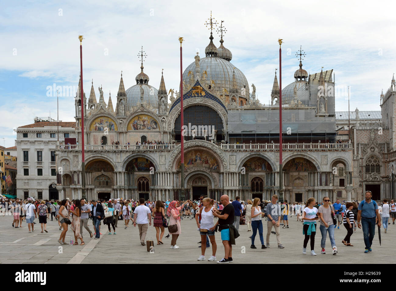 Turisti in piazza San Marco di fronte alla Basilica di San Marco di Venezia in Italia. Foto Stock