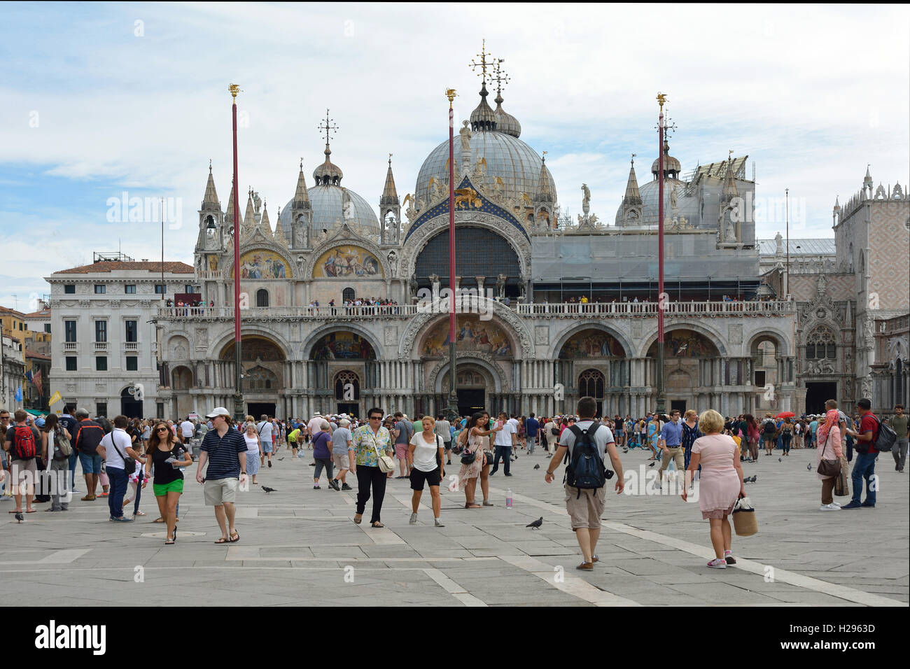 Turisti in piazza San Marco di fronte alla Basilica di San Marco di Venezia in Italia. Foto Stock