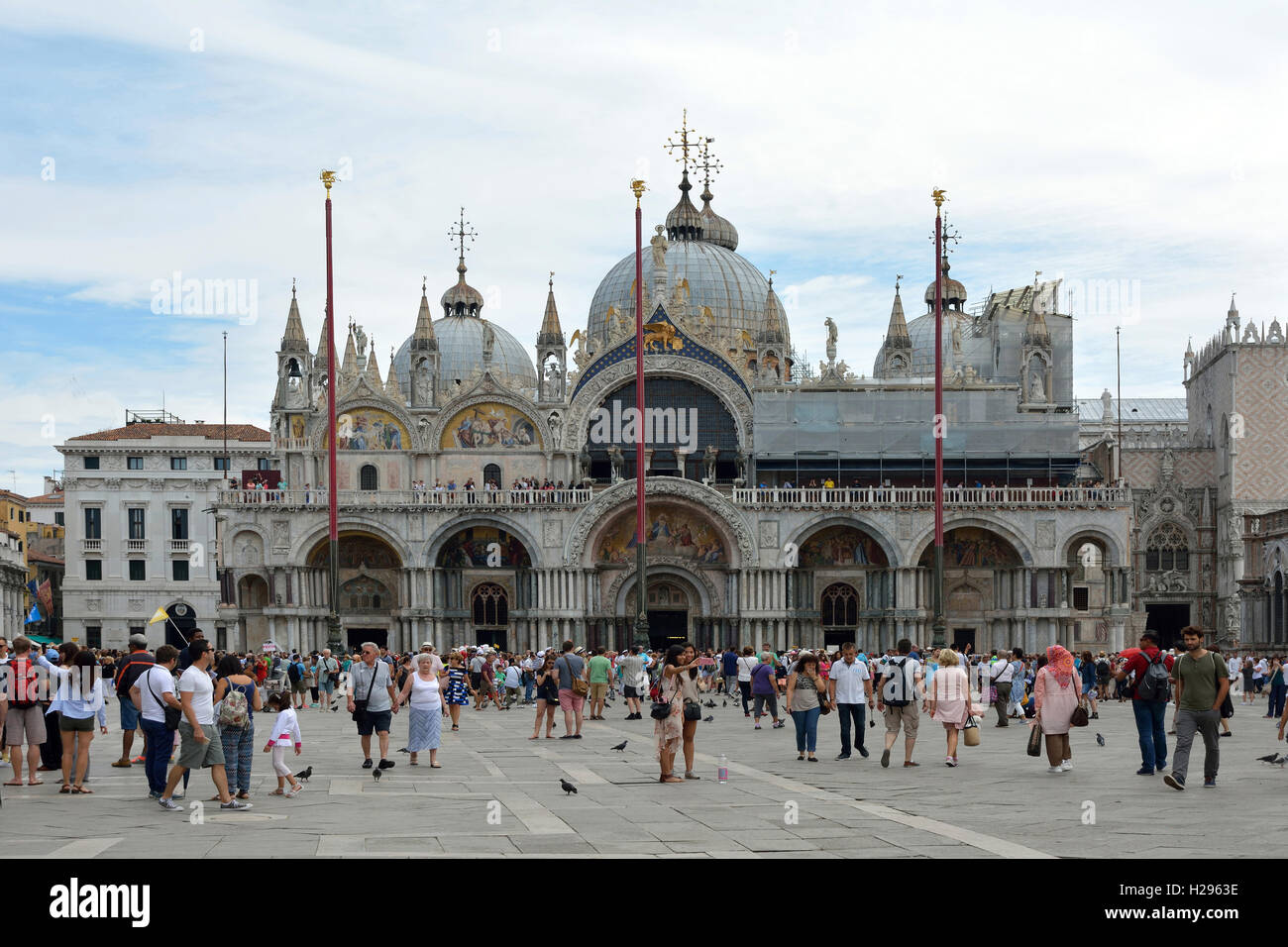 Turisti in piazza San Marco di fronte alla Basilica di San Marco di Venezia in Italia. Foto Stock