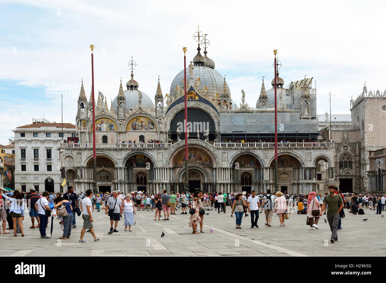 Turisti in piazza San Marco di fronte alla Basilica di San Marco di Venezia in Italia. Foto Stock