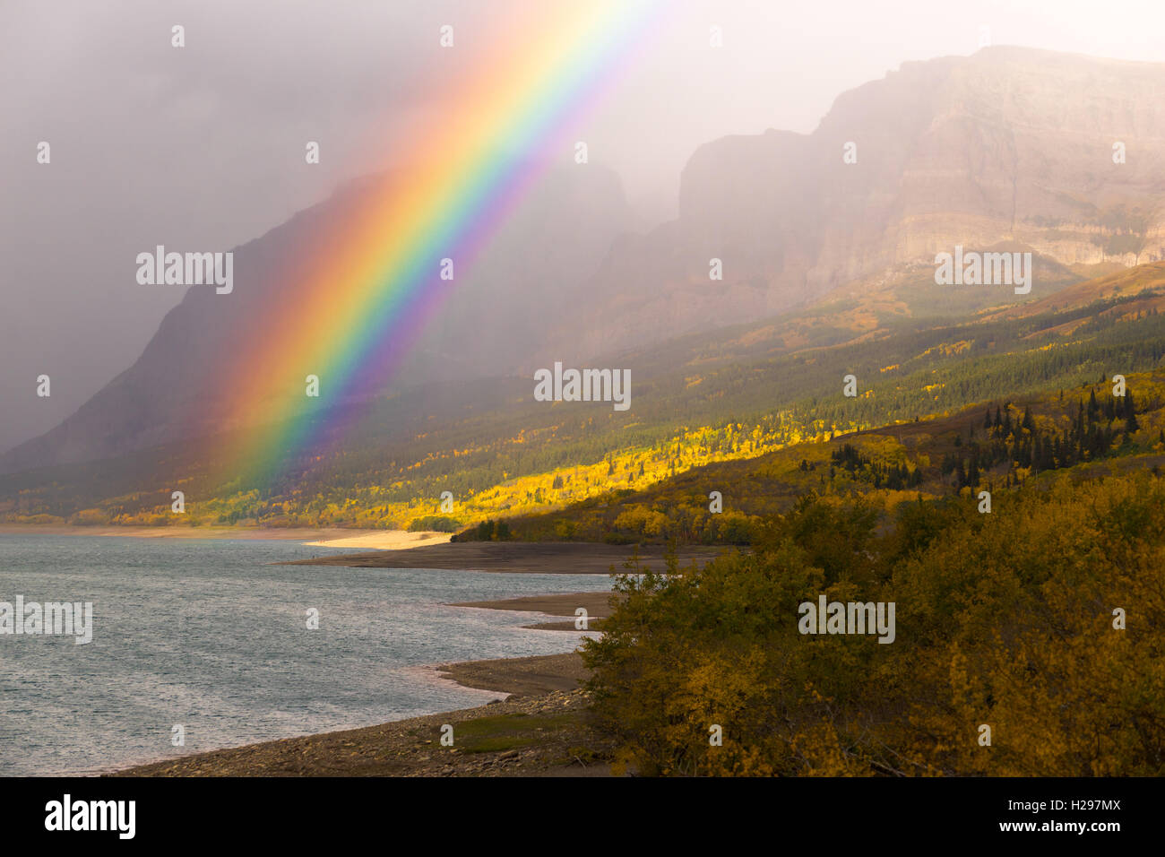 Una drammatica Rainbow appare in condizioni di nebbia presso il Glacier National Park Foto Stock