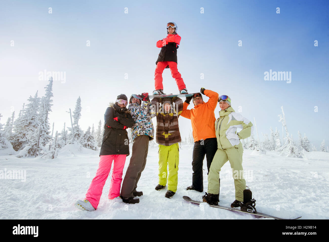 Gli appassionati di snowboard in posa sul cielo blu sullo sfondo di montagne Foto Stock
