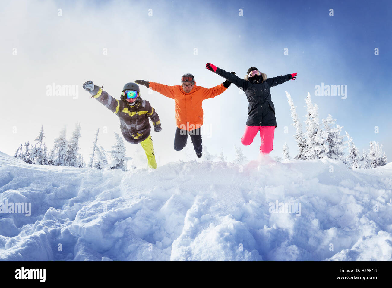 Gli appassionati di snowboard in posa sul cielo blu sullo sfondo di montagne Foto Stock