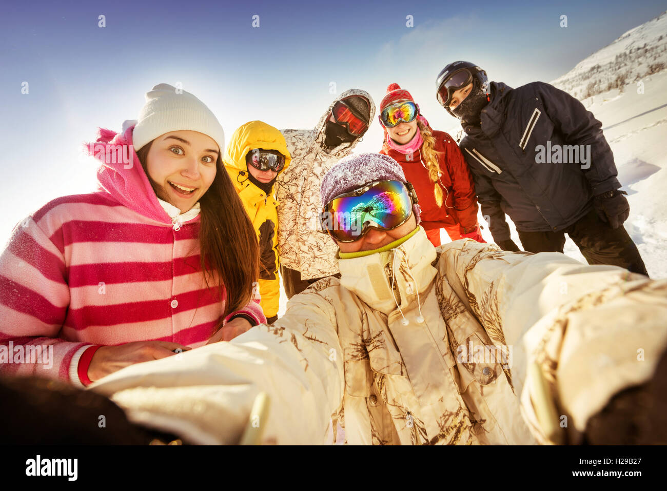 Gli appassionati di snowboard in posa sul cielo blu sullo sfondo di montagne Foto Stock