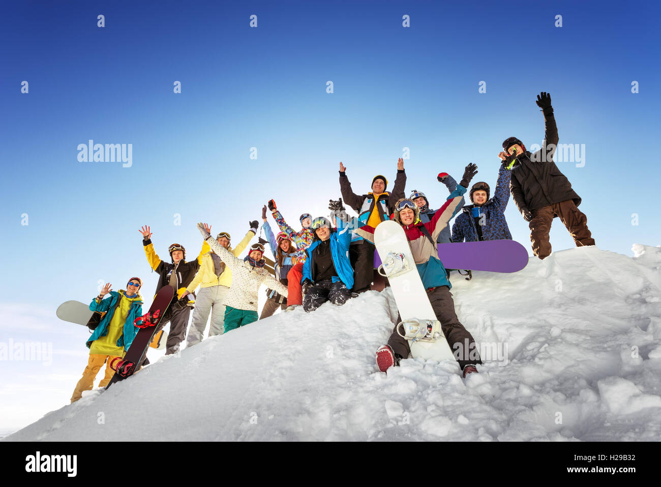 Gli appassionati di snowboard in posa sul cielo blu sullo sfondo di montagne Foto Stock