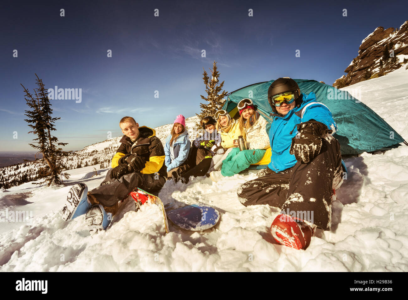 Gli appassionati di snowboard in posa sul cielo blu sullo sfondo di montagne Foto Stock