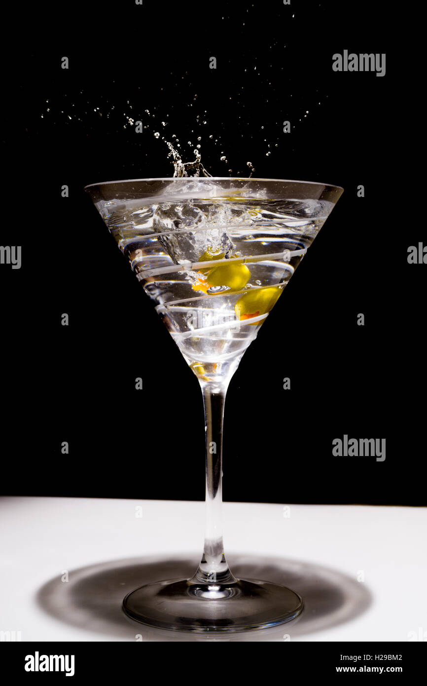 Due olive splash in una coppetta Martini Foto Stock