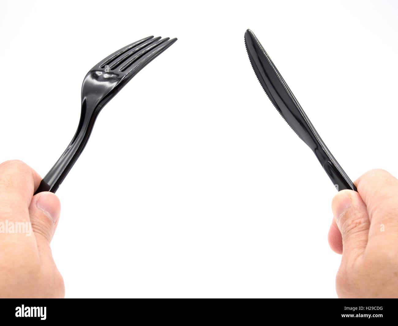 Mani in plastica nera forchetta e coltello agendo come pronti per il taglio Foto Stock