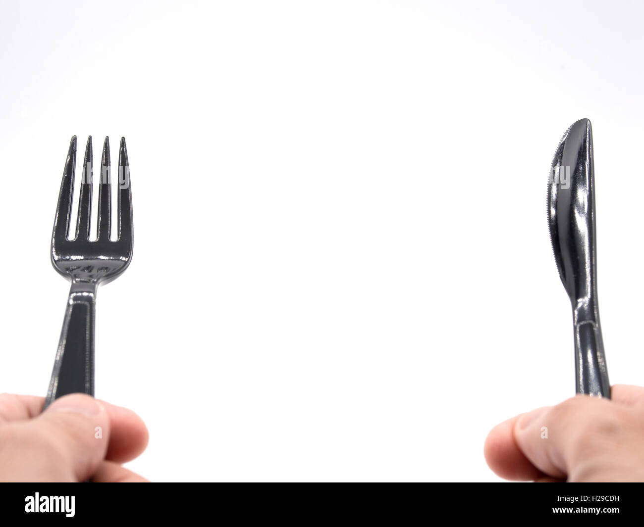 Mani in plastica nera forchetta e coltello Foto Stock