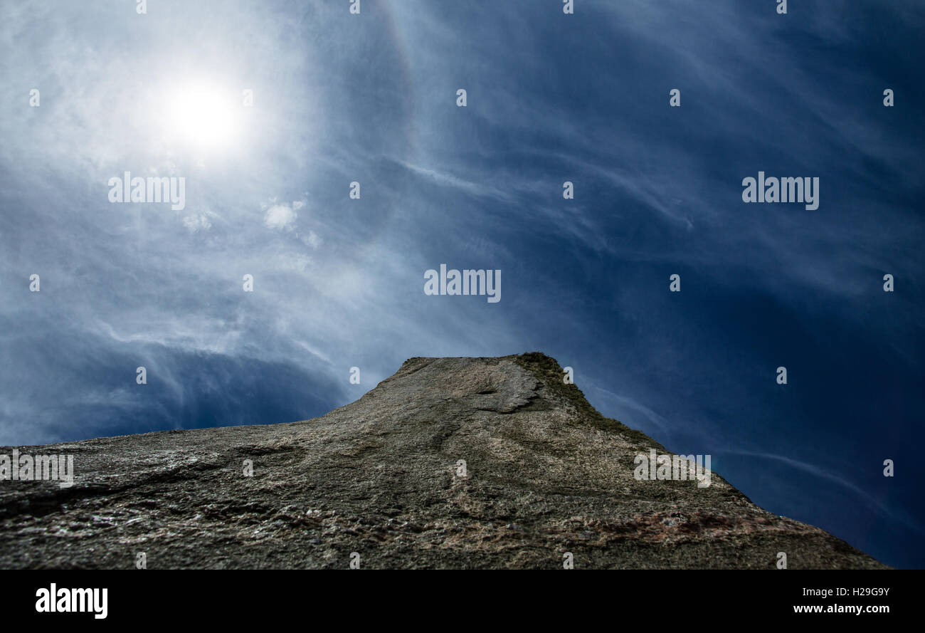 Una vista guardando in alto verso il sole a uno dei monoliti preistorici di Callanish sull' isola di Lewis, Ebridi Esterne, Scozia Foto Stock