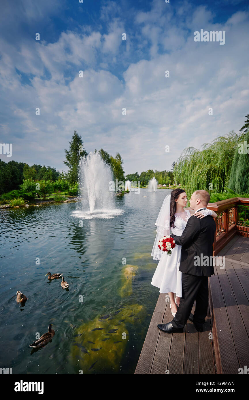Amare coppie in viaggio di nozze in piedi e baciare in prossimità di acqua Foto Stock