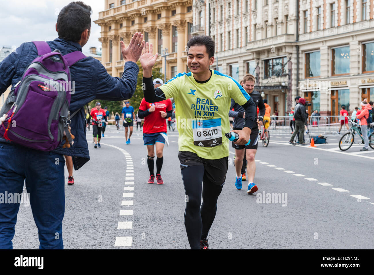 Mosca, Russia, 25 Settembre 2016: Mosca Annuale Internazionale Maratona avviene nella città questa domenica. Corridori provenienti da più di 70 paesi partecipano a questo evento sportivo. La distanza della maratona è pari 42,2 km (26,2 miglia). Il percorso della maratona inizia e termina in corrispondenza del Luzhniki Olympic complesso e va oltre le più impressionanti monumenti di Mosca. Alta cinque per guide di supporto. International partecipante. Credito: Alex Immagini/Alamy Live News Foto Stock