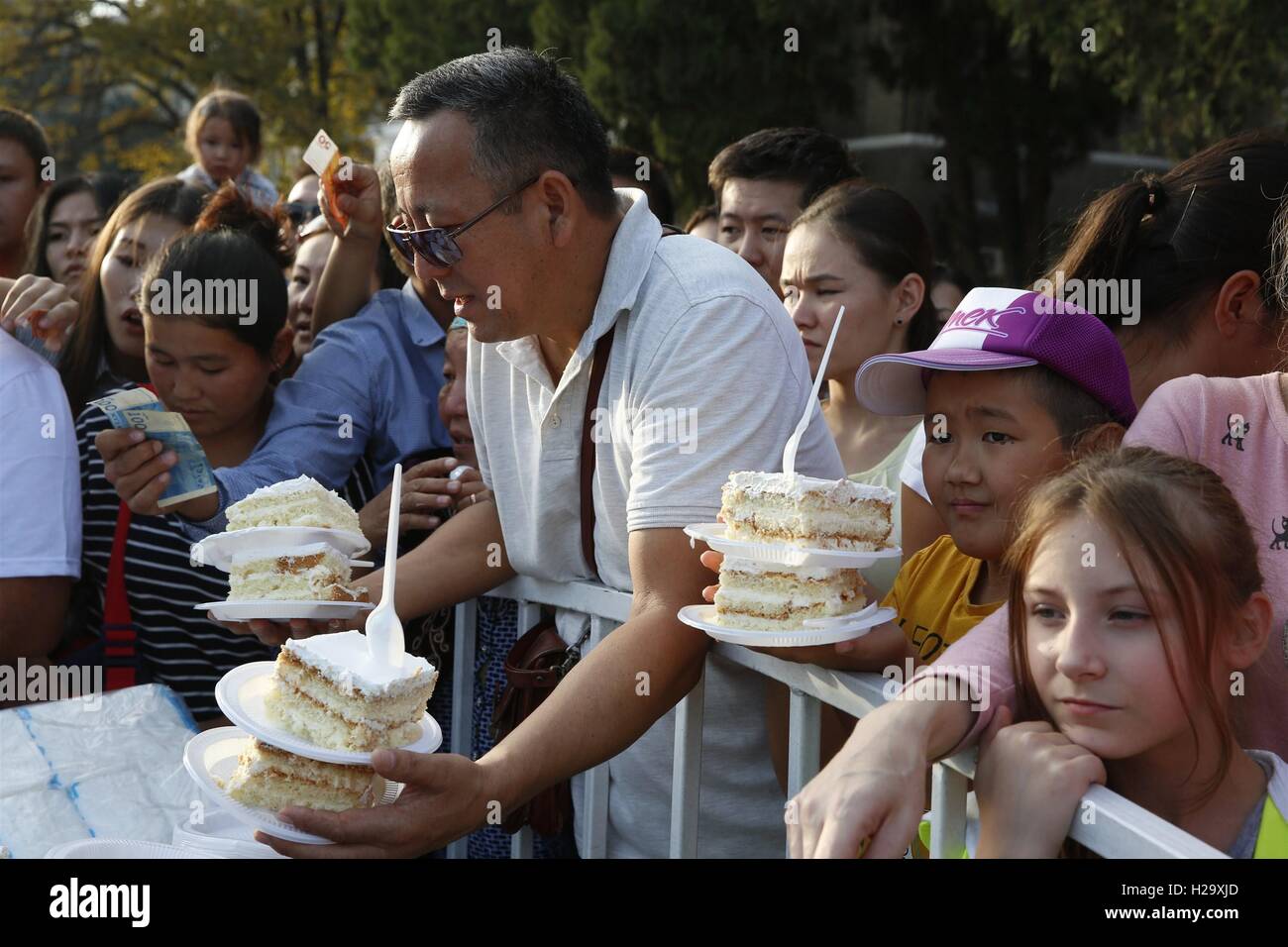 Bishkek, Kirghizistan. Xxv Sep, 2016. La gente compra dolci presso un parco a Bishkek, Kirghizistan, Sett. 25, 2016. Una torta di misura 1,5 tonnellate e 100 metri quadrati è stata preparata da un gruppo di panificatori del Kirghizistan di domenica a Bishkek. La torta è stata in vendita al pubblico a raccogliere fondi per beneficenza. Credito: Roman Gainanov/Xinhua/Alamy Live News Foto Stock