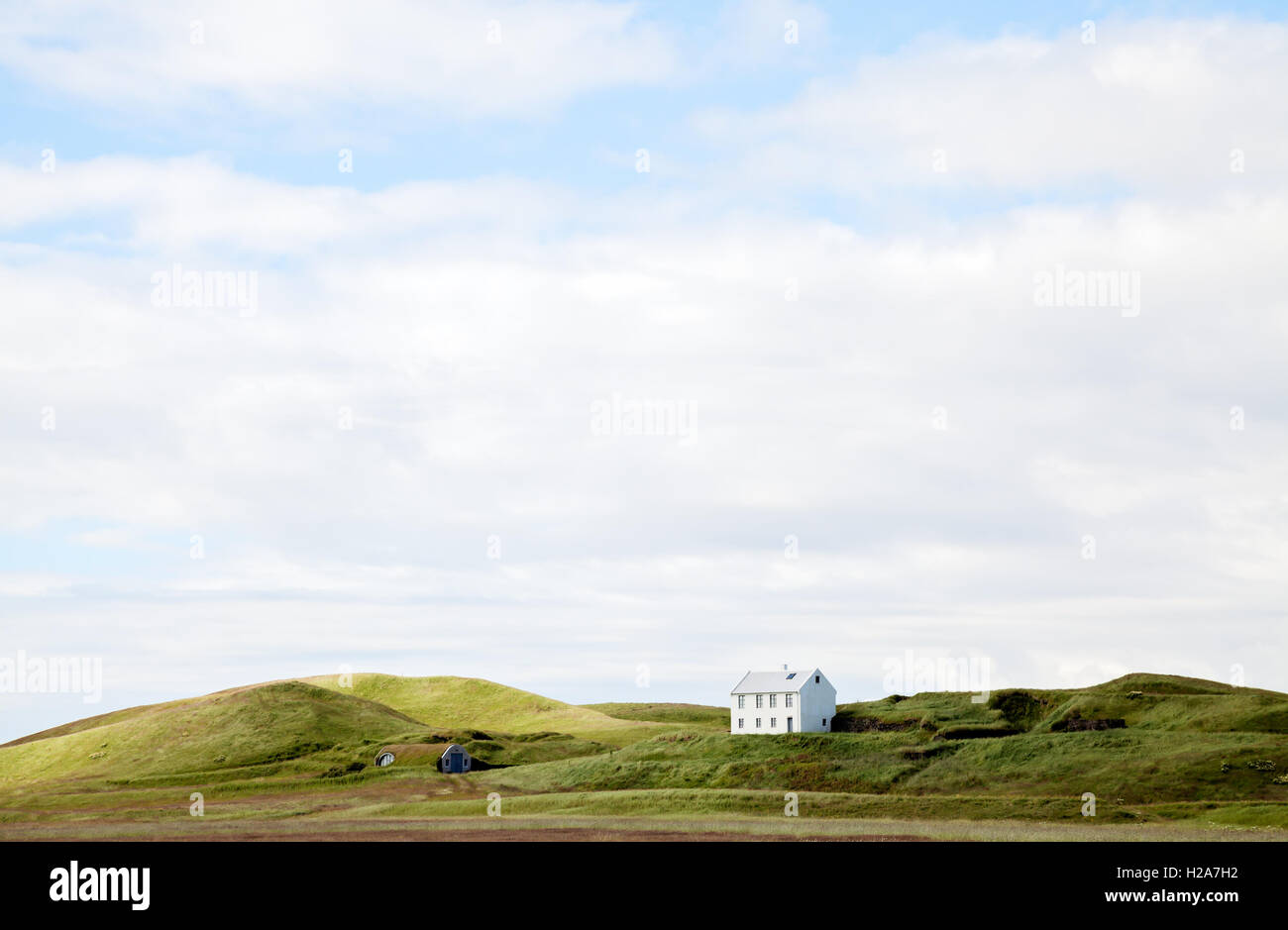 Bella casa bianca contro il cielo nuvoloso, Islanda. Foto Stock